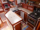 The galley.  Refrigerator under the island, freezer outboard, double sinks, gas stove, a secure place to work underway.