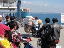 An over loaded motor cycle just coming off the ferry at Samal Island.