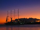A commercial "tall ship" slips out of Papeete Harbour into the sunset