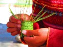 A Tarahumara woman weaves a traditional basket from the long pine needles