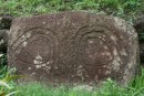 A primitive carved stone in a yard in Hanaiapa - Nuku Hiva