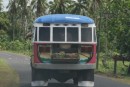 One of the many colorful buses of Samoa!  Notice the woven baskets of coconuts in the back!