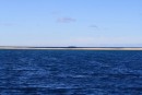 View from the anchorage across the sand spit at high tide.  Limu Island in the distance.