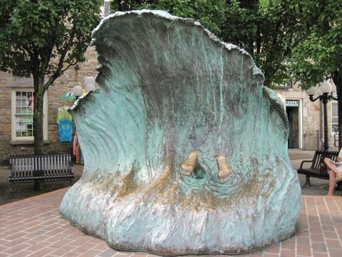 A sculpture showing a dive into a breaking wave