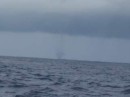 A waterspout near afternoon convection activity building over warm seas.