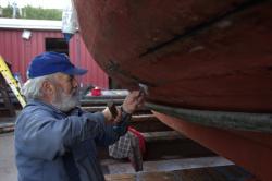 Rick caulking his wooden fishing boat