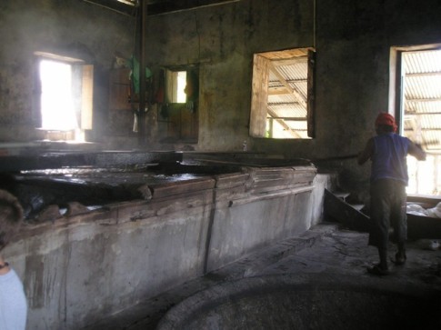 The cane juice is boiled in the copper bowls and ladled by hand to the next copper..JPG