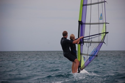 Dad Jamie teaches 11-year-old Niall from s/v Totem to windsurf on Allan