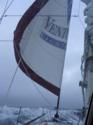 Partly furled jib in strong following winds