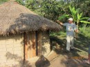 Joe standing at an indigenous hut on the coffee plantation.