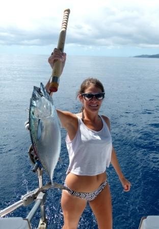 Linds proudly holds up the big pacific bonito she reeled in on the hand line.