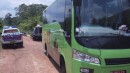 Bus and entourage (police escort and local government officials) parked in the jungle looking for honey