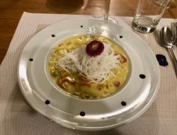 Yummy edible: A delicate curry with rice noodles, drops of balsamic and edible flower.