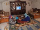 Berber women watching TV by satellite in their mountain cave dwelling 