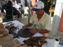 I saw this man hand rolling cigars at a street market.