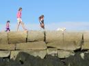 A family enjoying their long walk out to the Rockland Lighthouse on the 7/8 mile breakwater, Maine, USA.