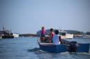 Lobsterman, wife and daughter head out to their boat to go fishing, Stonington, Deer Isle, Maine, USA