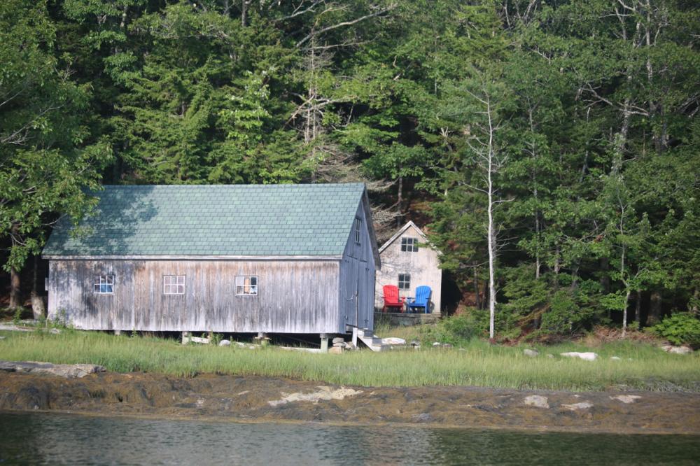 Boat shed with adirondeck chairs on the shore near Robinhood Marina, Maine, USA