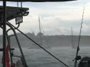 Squall in Port Mahon Harbour- two boats have hooked their anchors and are moving towards the channel
