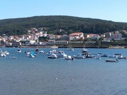 Looking across the ria from Corcucubion.: Jobiska anchored centre  harbour away from the mooring buoys.