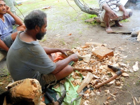 Another carver from a neighboring village, working on a dolphin.