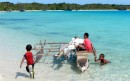 An outrigger that a couple of the villagers used to get to the beach party provides an impromtu playground for some of the local kids.