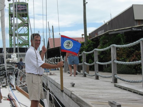 Hoisting the Belize Courtesy flag after checking in