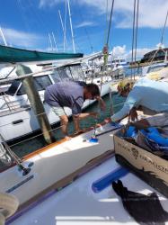 "During"  John Outboard Pulling Masking Tape While Non-Skid is Applied: Janet and I work together pulling masking tape as GIddo sped along applying Kiwi Grip on the main deck.  Cabin top paint and a little bit of non skid was done.  I couldn