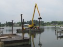 The barge operator lifts the anchoring spud in preparation for moving to the channel.