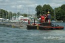 When the barge is full, one of the work boats brings it back to the dock. Notice how much lower it rides in the water...
