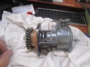 This photo shows the complete raw water pump assembly removed from the engine.  One the left is the gear that is driven by the same gear in the engine that drives the cam shaft.  Next is the mounting plate that is bolted to the engine to hold the pump assembly in place.  The next part of the pump are the places where the bearings and seals are housed.  There is a slot between the oil seals on the left and the water seals on the right so neither is in contact with the other.  A short length of drive shaft passes into the pump chamber on the far right.   