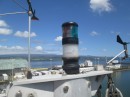 This pic shows our mast head gear.  The windex wind indicator is on the left.  We installed that in New Zealand.  The anchor light/tri-color nav light/strobe light is in the middle.  I converted that to LED lighting before we left the states in 2008 and it has given us many years of power efficient service.  On the right is wind direction and speed sensors for the nav instruments in the cockpit.  This device got hit by a bird in Tazmania but we straightened it out and it has been working adequately ever since.
