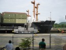 Everyone who visits the Miraflores visitor center gets to see the ships passing through the canal this close.  This particular ship is a US Navy supply vessel that just paid $135,000 in toll alone to go through the canal.  In addition to the tolls they pay for two pilots, deck hands to manage the lines, and other things.  This photo shows one of the mules (locomotives) that help pull the ships through the canal and make sure they stay centered as the panamax ships only have two feet of clearance on each side.  The mules proved about 30% of the energy needed to pull the ships through.  The ship provides the rest with its engine.  8 mules are needed for a ship this size.