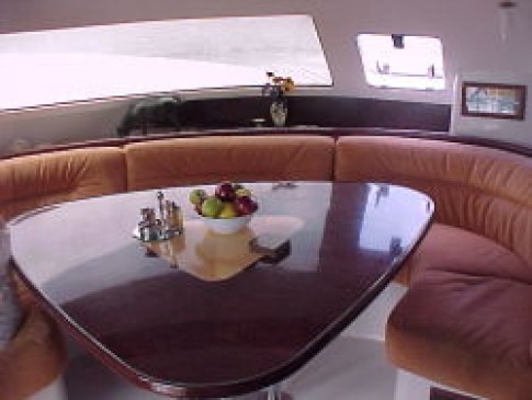 Saloon table and seating with windows looking forward and to port/starboard
