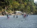 Volleyball in sparkling sand.
Camp kitchen in the background.