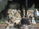 This tiny wood stove is what heats the water tank that fills the cast iron tub inside the bath house.