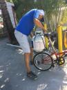 Putting propane tank back on bike after refilling it at Red Coconut RV Park