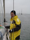 Tom stows dock lines as Myananda follows other sail boats from the marina to the start line.