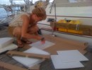 Kate applies contact cement to join pieces of starboard and foam as she "customizes" our throw cushions. The starboard was used to stiffen the foam and provide a more back support. Geesh!
