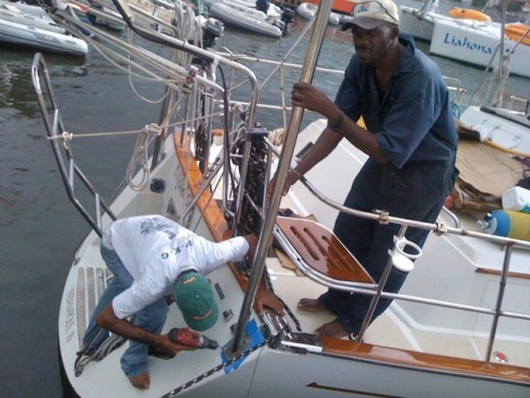 Ronell and Alan  position the new wind generator pole for installation on the transom. Properly aligning the angled base and keeping the pole on a vertical axis in all directions while the boat bobbed about was challenging. Untimately you eyeball it and say "go for it".