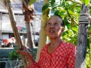 This woman was concentrating on using a long stick to knock down fruit from a tree branch high above.