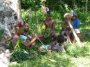 preteens hang out just off the main group.  The blond headed boy holds a bamboo which is used to make a drumming sound