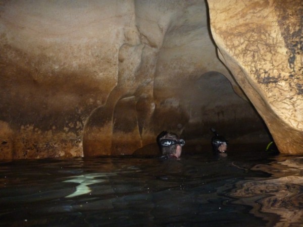We swam under a ledge into this dark cave without outside light