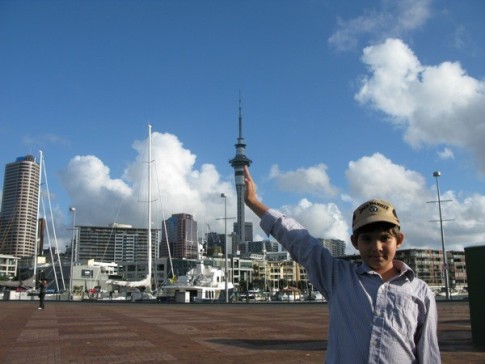 Cole leaning on the Sky Tower in Auckland.  In the photo, we are in Viaduct Harbor.