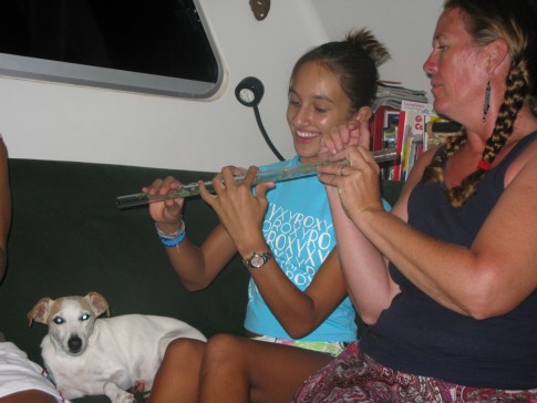 Cammi learning flute from Bobbie Jo while Apple listens; Tahuata, Marquesas