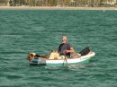 sailor with dog, guitar, and other gear headed back out to his anchored boat
