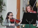Kira and her viola teacher playing holiday tunes on State Street