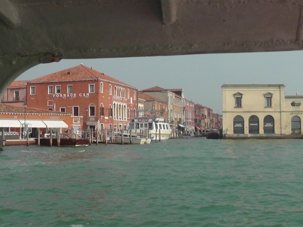 Approaching Murano Island, red building on left and yellowish building on the right are advertising Glass Factory.