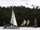 Two traditional Polynesian catamarans or wakkas vie for a place with a modern Lagoon 380 catamaran in the Friday afternoon Vava