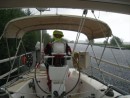 Marty at the helm in the Crinan Canal during a heavy downpour 13 May